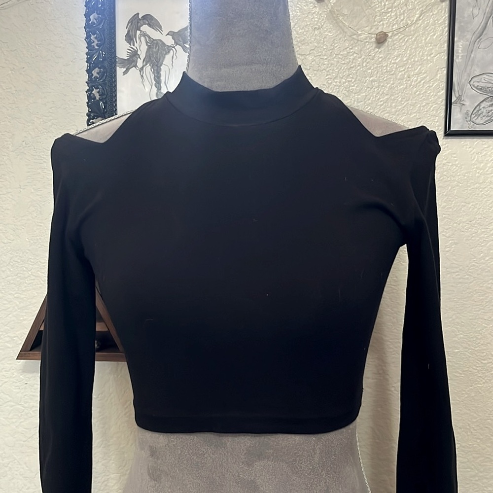 Long sleeve black crop top with cutout shoulders.